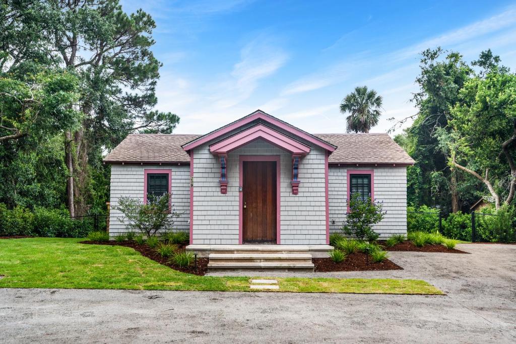 a small white house with a red door at Folly Vacation 209 East, Modern, Sassy and 3 Blocks to the Beach in Folly Beach