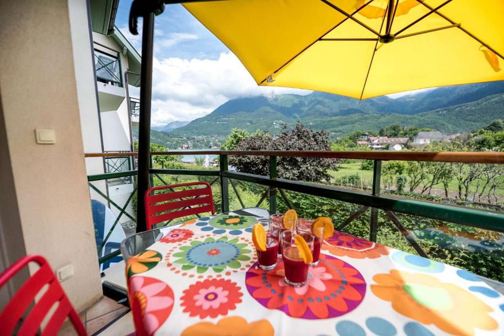 a table with an umbrella on a balcony at La Carte Postale in Duingt