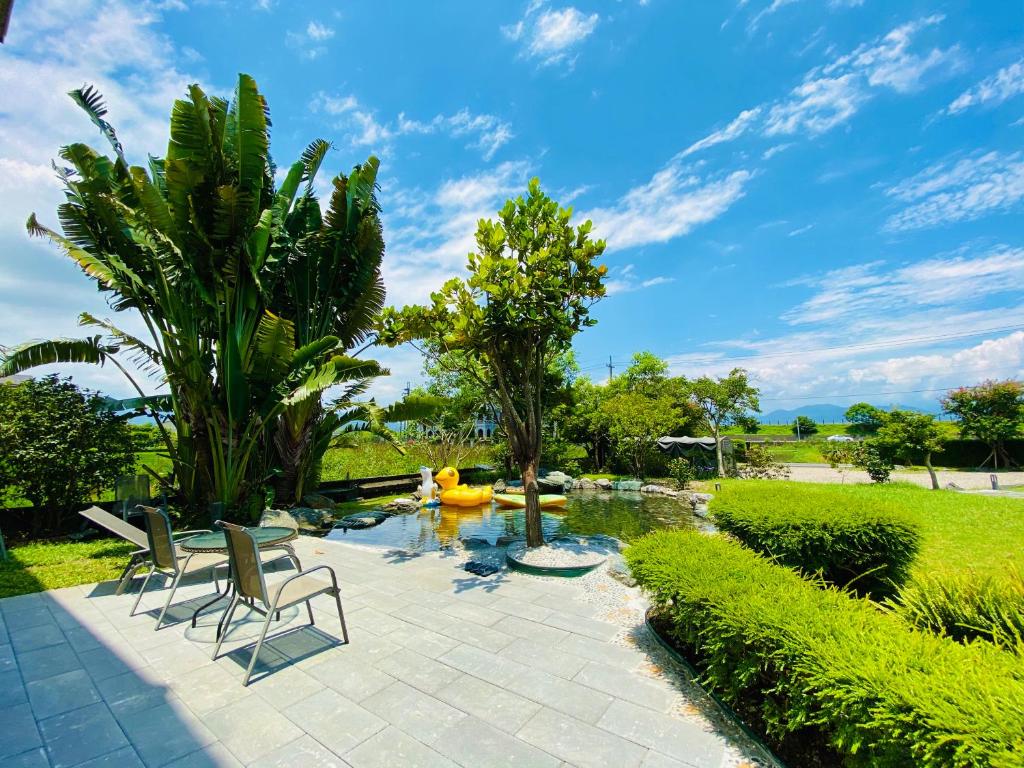 a patio with two chairs and a pond at Yun Tien Feng Chuan B&amp;B in Dongshan