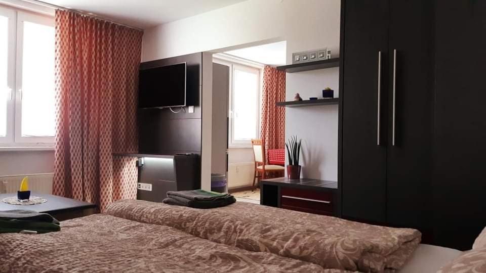1 dormitorio con cama, escritorio y espejo en Szoba konyha lakas, en Komárno