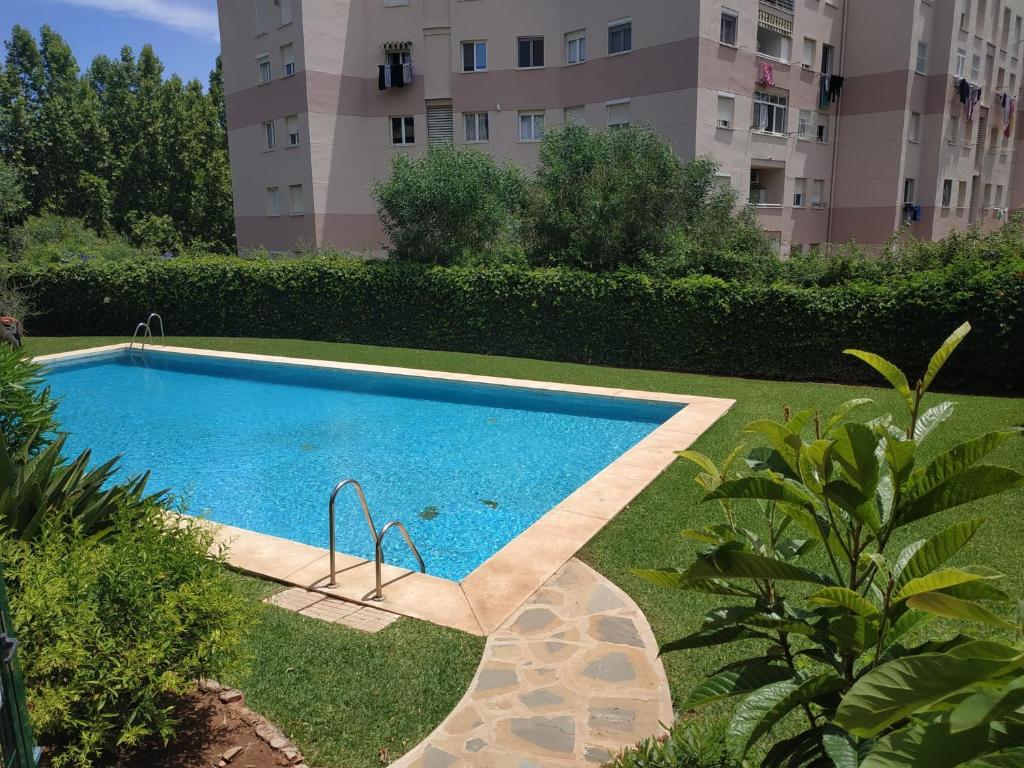 a swimming pool in a yard next to a building at Amplio apartamento Marbella in Marbella