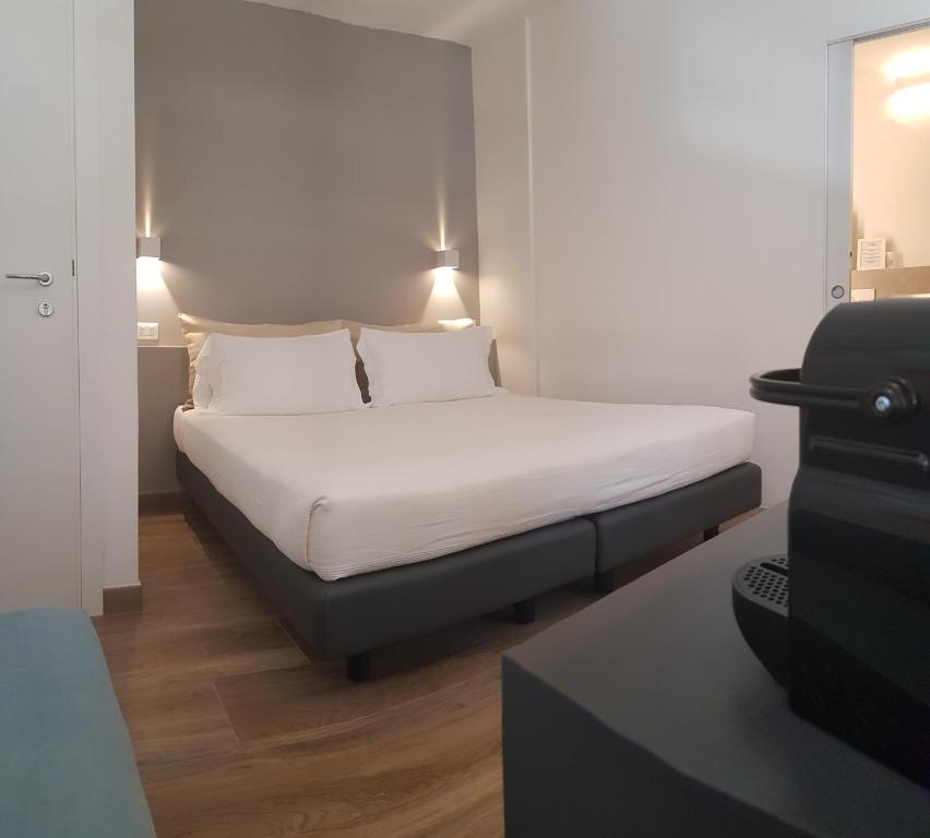 サルザーナにあるSarzana's Roomsのベッド(白いシーツ、枕付)