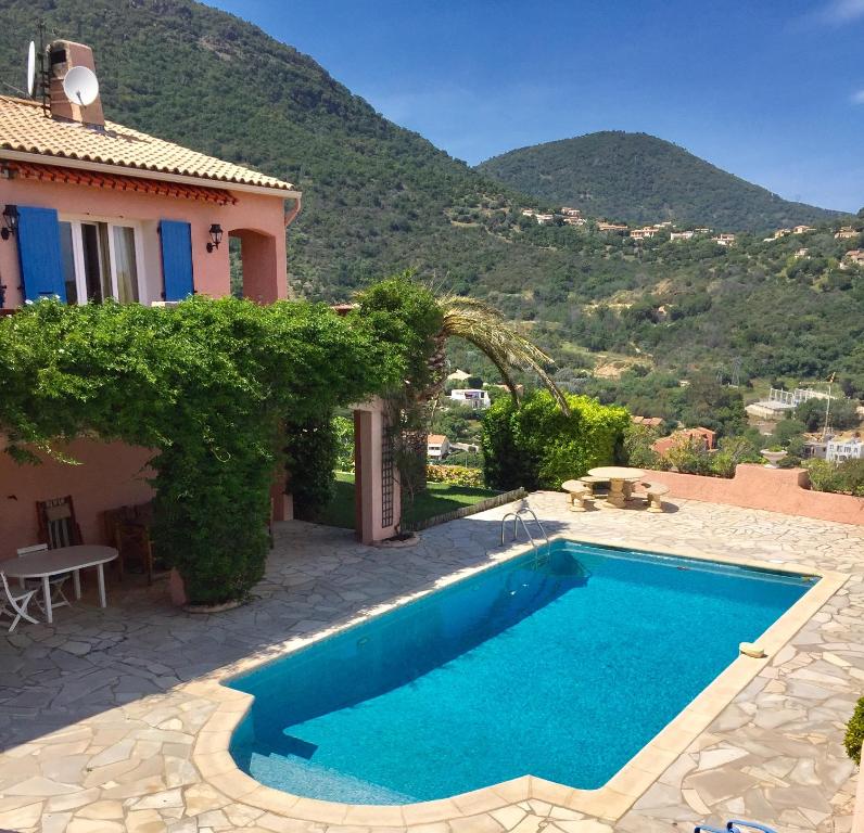 a swimming pool in front of a house with a mountain at Rez-de Villa Piscine in Cavalaire-sur-Mer