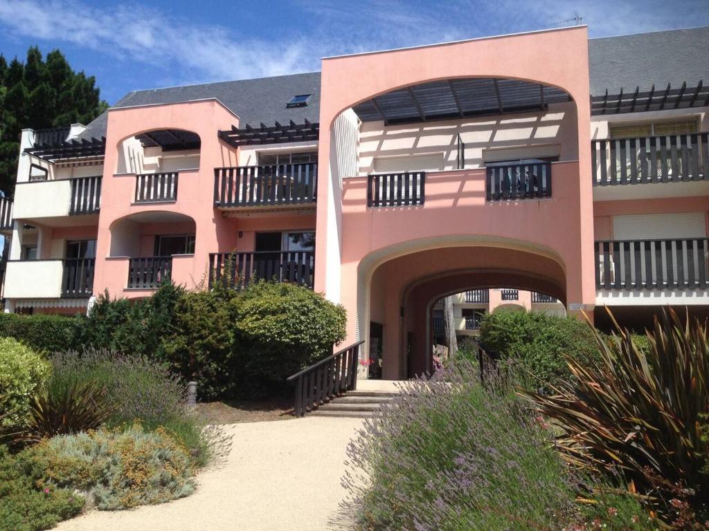 un edificio rosa con un passaggio pedonale di fronte di Appartement La Baule;Pornichet a La Baule