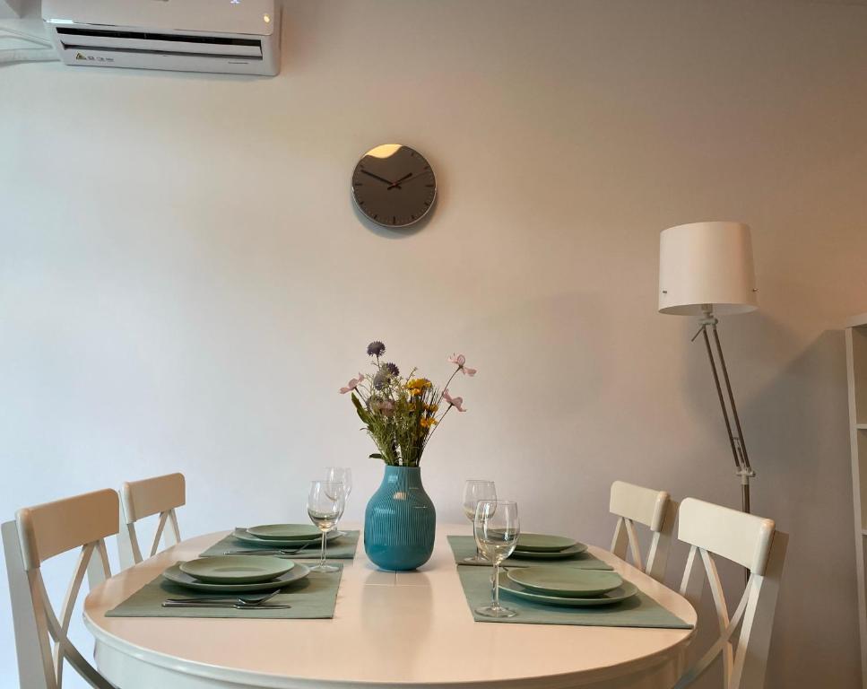 a dining room table with a blue vase with flowers at Deko Apartments Alezzi Beach Mamaia in Mamaia Nord