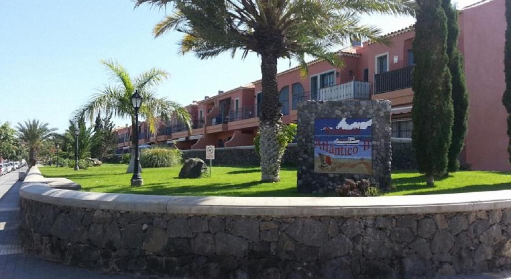 ein Schild vor einem Gebäude mit Palmen in der Unterkunft Residencial Atlantico I in Costa Del Silencio
