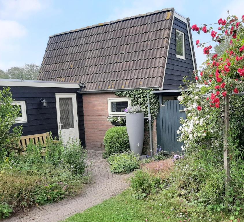 a house with a black roof and a garden at Mahil-Laya in Meppel