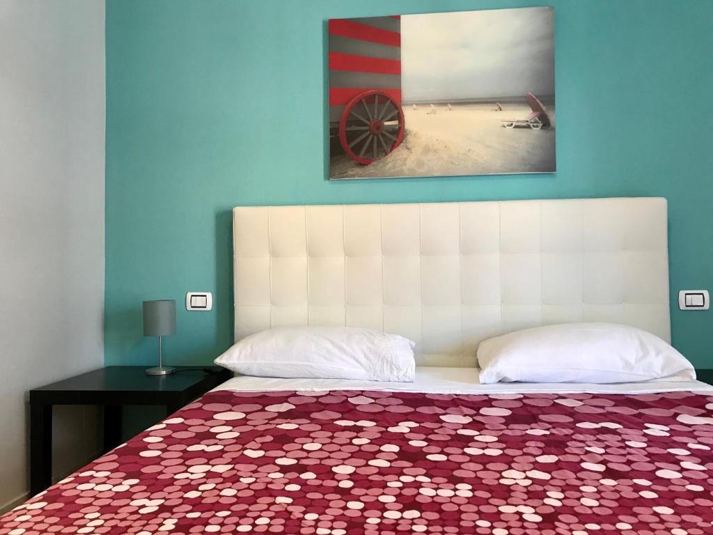 a bedroom with a bed with a red and white bedspread at ROOM 110 BARI -guesthouse- in Bari