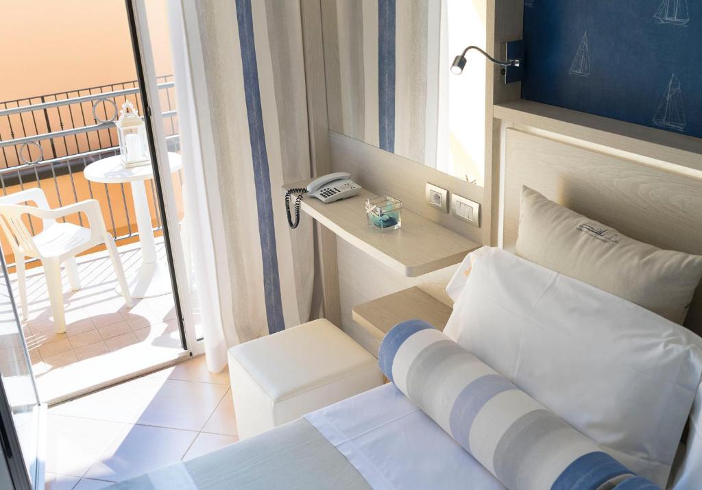 a small room with a bed and a balcony at Hotel Vanni in Misano Adriatico