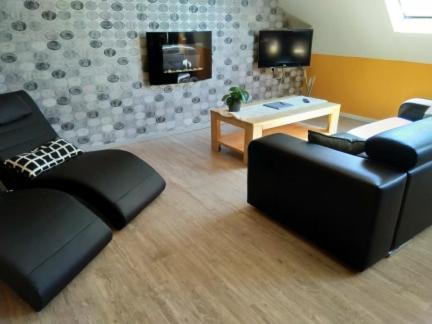 a living room with a couch and a table at B&B Hoeven Het Gehucht in Overpelt