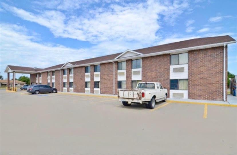 un grand bâtiment en briques avec un camion blanc dans un parking dans l'établissement Econo Inn, à Columbus