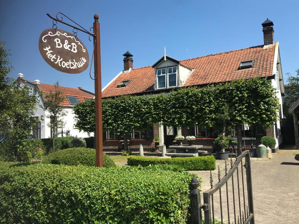 um sinal para um restaurante em frente a uma casa em Het Koetshuis em Kamperland