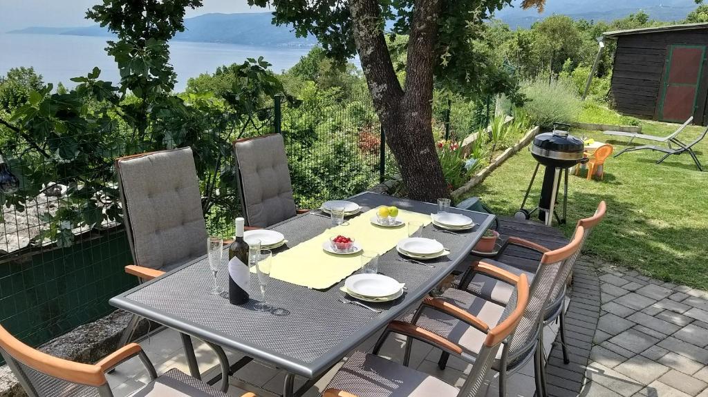 una mesa y sillas en un patio con parrilla en Apartments Turan en Rijeka