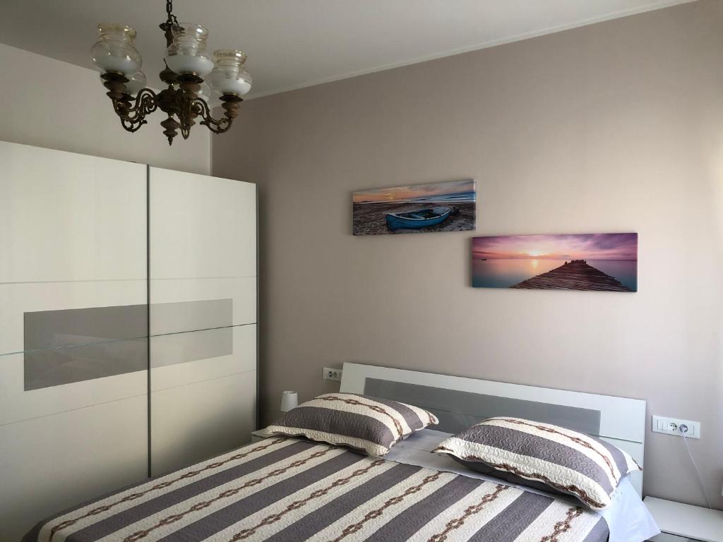 um quarto com uma cama com duas almofadas e um lustre em Apartment Batinica em Sibenik