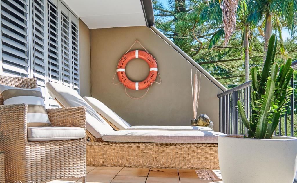 a large white clock sitting in the middle of a patio at Julians Apartments in Byron Bay