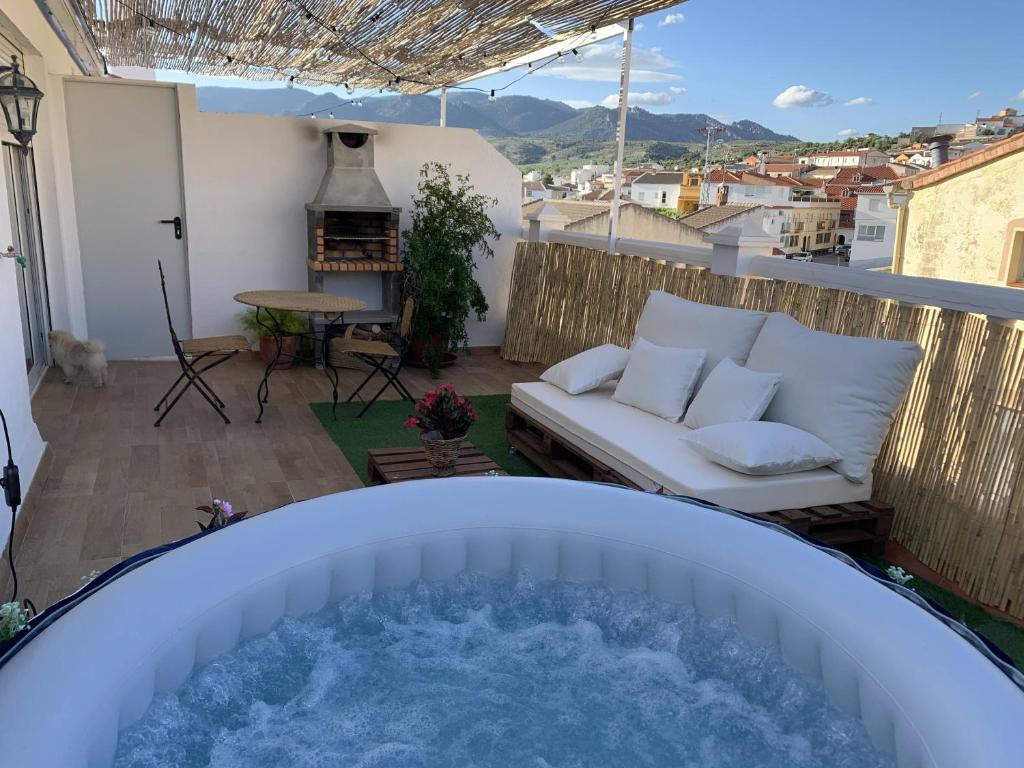 a hot tub on a balcony with a couch at Apartamentos CAZORLA-ALCON in Pozo Alcón