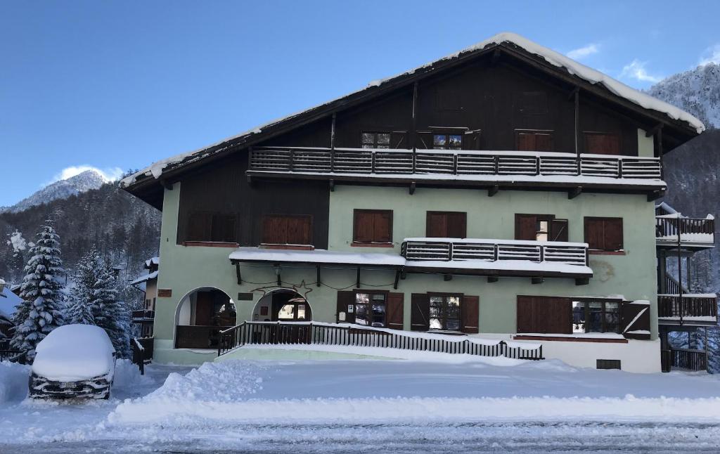 un grande edificio con neve di fronte di Chalet della Luna ATTENZIONE lavori di ristrutturazione in corso IMPALCATURA a Claviere