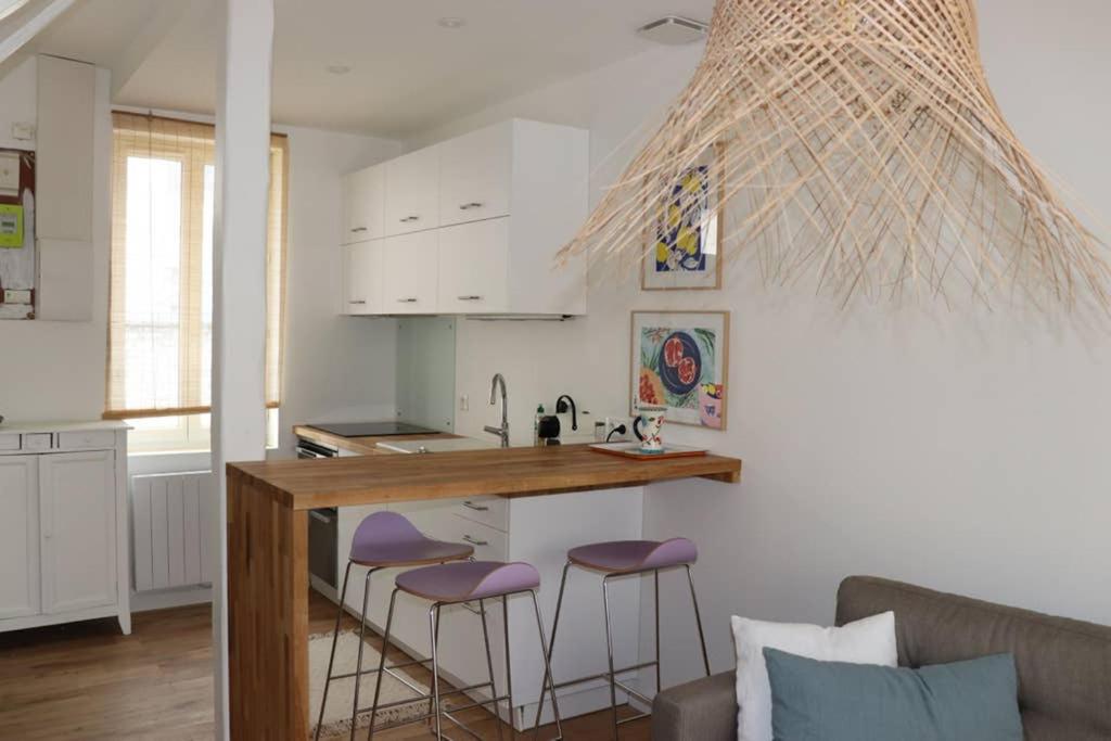 a kitchen with a counter and stools in a room at Maison BB Burgonce Bohème centre avec extérieur WIFI gratuit et NETFLIX in Niort