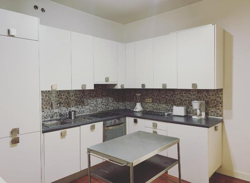 a kitchen with white cabinets and a table in it at Apartamento de Lujo I en Madrid Centro in Madrid