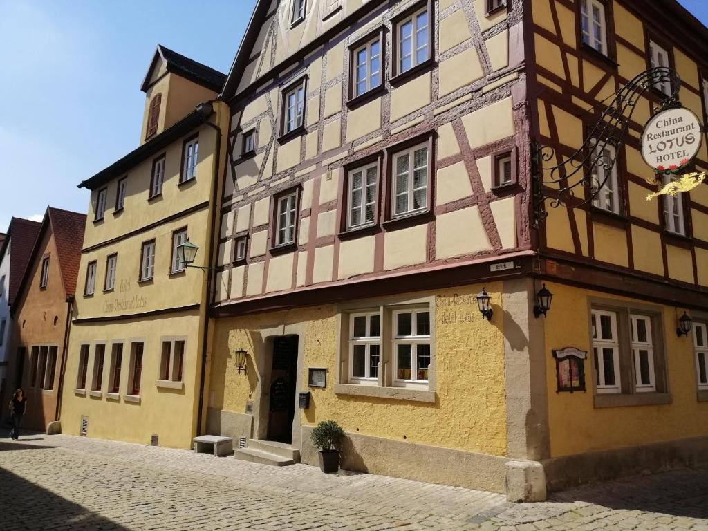 un edificio en una calle adoquinada de una ciudad en China Restaurant Hotel Lotus, en Rothenburg ob der Tauber