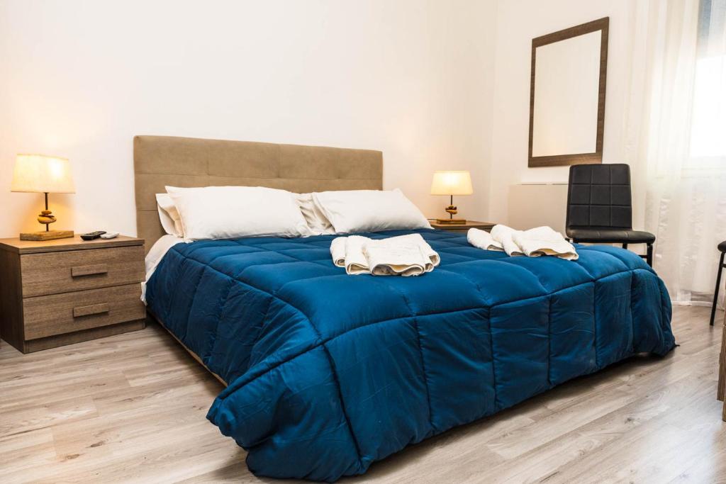 ein Schlafzimmer mit einem blauen Bett mit zwei Handtüchern darauf in der Unterkunft La Casa del Poeta in Porto Torres
