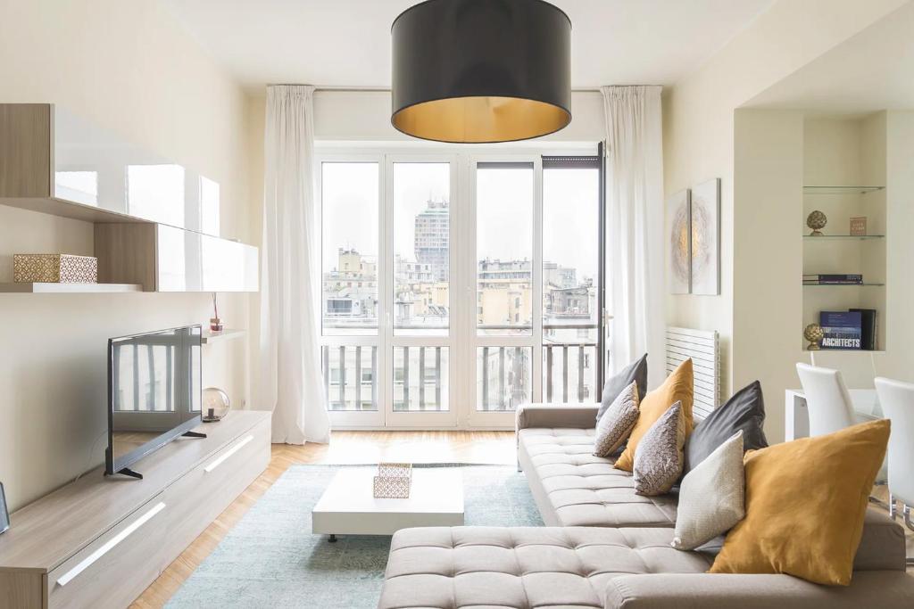 a living room filled with furniture and a tv at Heart Milan Apartments San Sepolcro Duomo in Milan