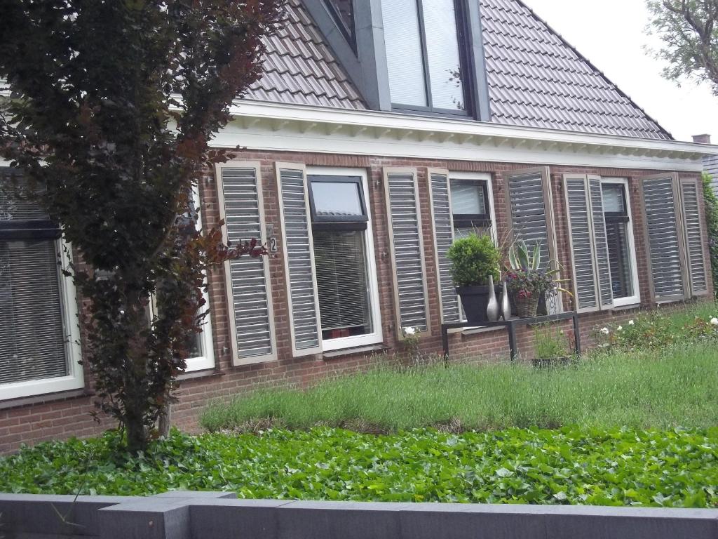 una casa de ladrillo con ventanas y plantas en el patio en 't Griene Hemeltsje, en Wijckel