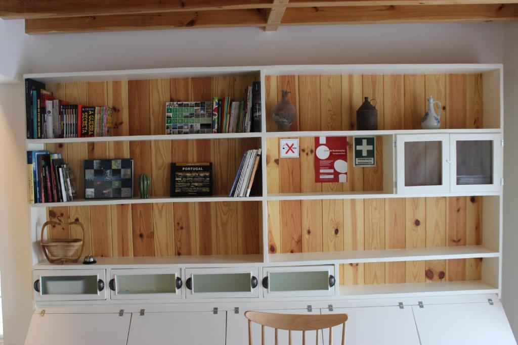 Habitación con paredes de madera y estanterías con libros. en Casa da Ponte Branca en Ancião