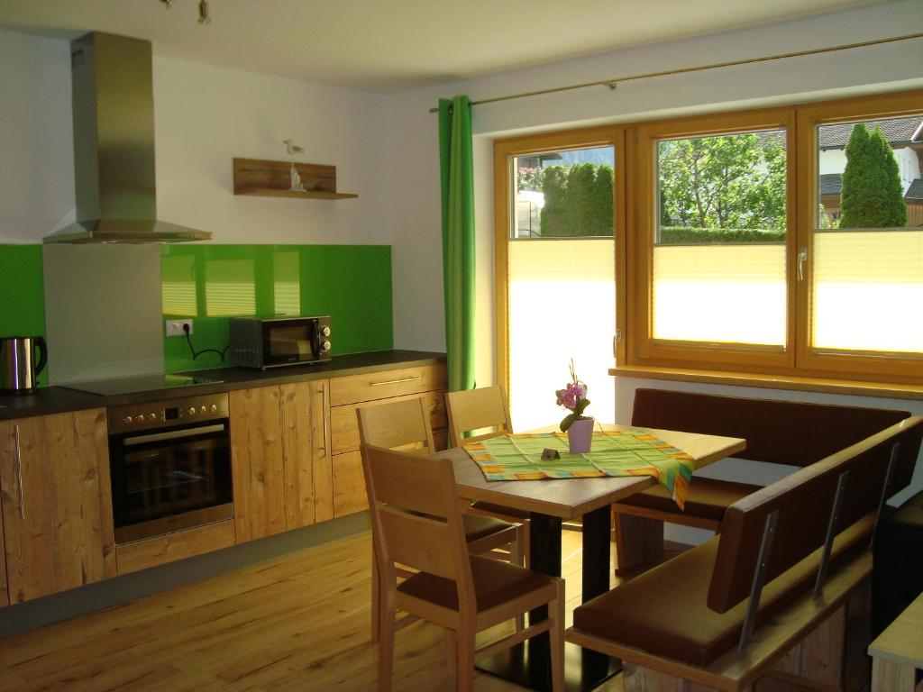 a kitchen with a table and a kitchen with green walls at Haus Alexander in Pfunds