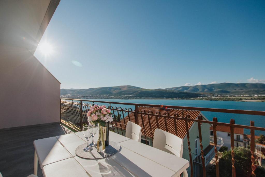 una mesa con un jarrón de flores en el balcón en Blaise en Trogir