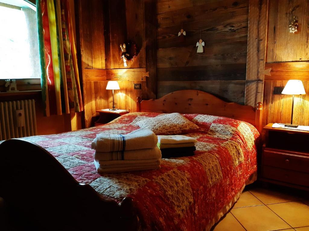 Schlafzimmer mit einem Bett mit einer roten Bettdecke in der Unterkunft Fiocco di neve in Pila