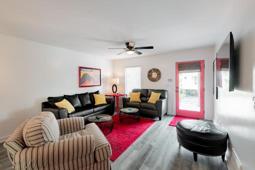 una sala de estar con 2 sofás y una alfombra roja en Folly Vacation Perfect Purple Palace Apt A, en Folly Beach
