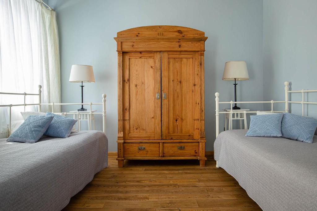 a bedroom with two twin beds and a wooden cabinet at Karlamuiza Country Hotel in Kārļi