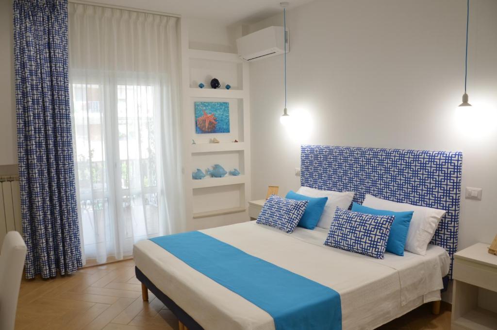a bedroom with a bed with blue and white pillows at Sorrento Maison Lurò in Sorrento