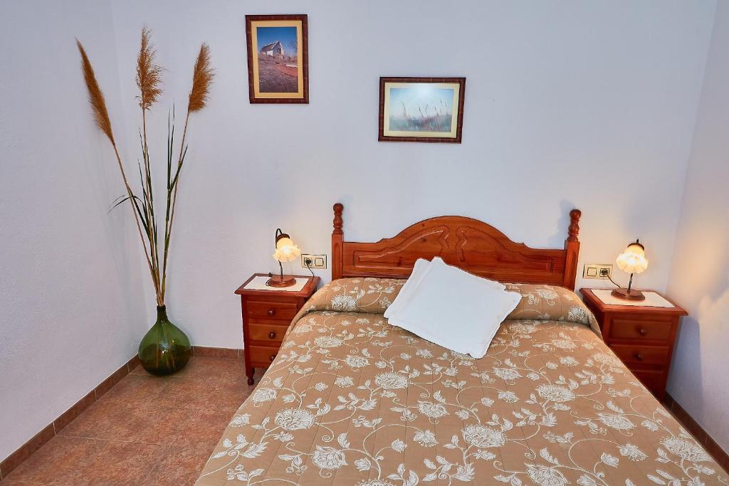 1 dormitorio con 1 cama con 2 mesitas de noche y 2 lámparas en Lo Segador, en El Poblenou del Delta