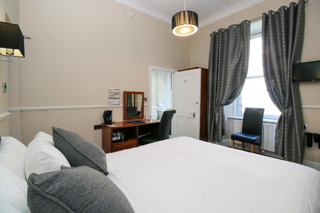 Postel nebo postele na pokoji v ubytování Kelvingrove Hotel - Sauchiehall St