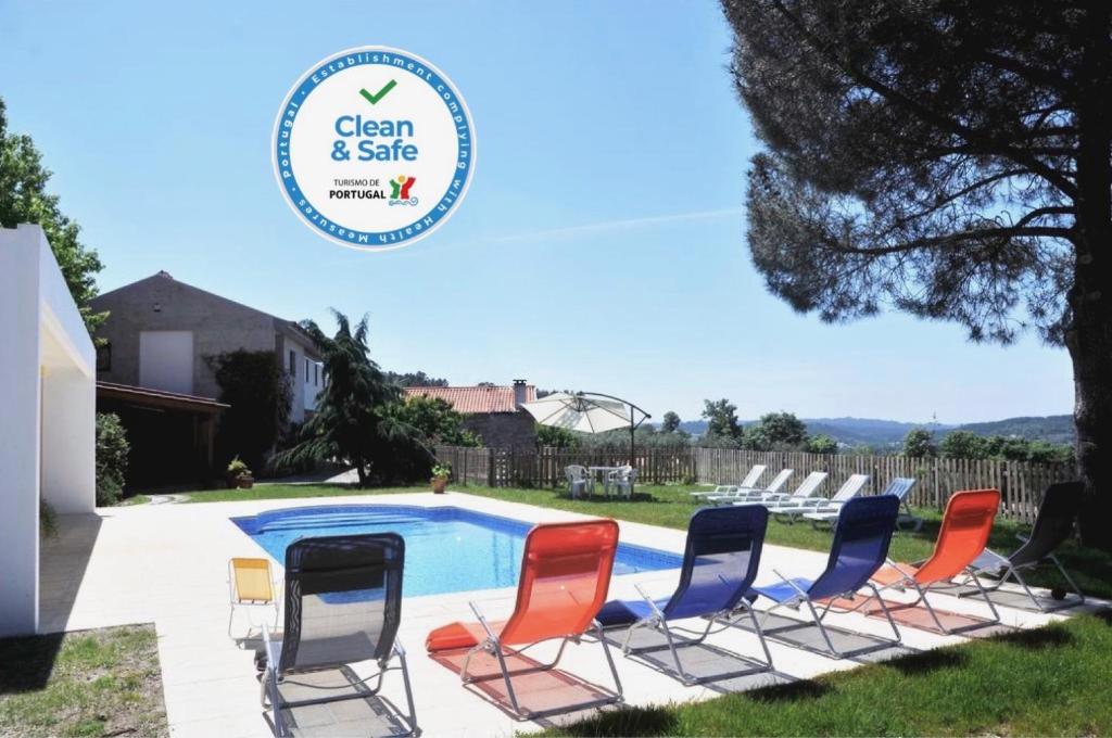 a group of chairs next to a swimming pool at Quinta do Vale Sanguinho in Seia