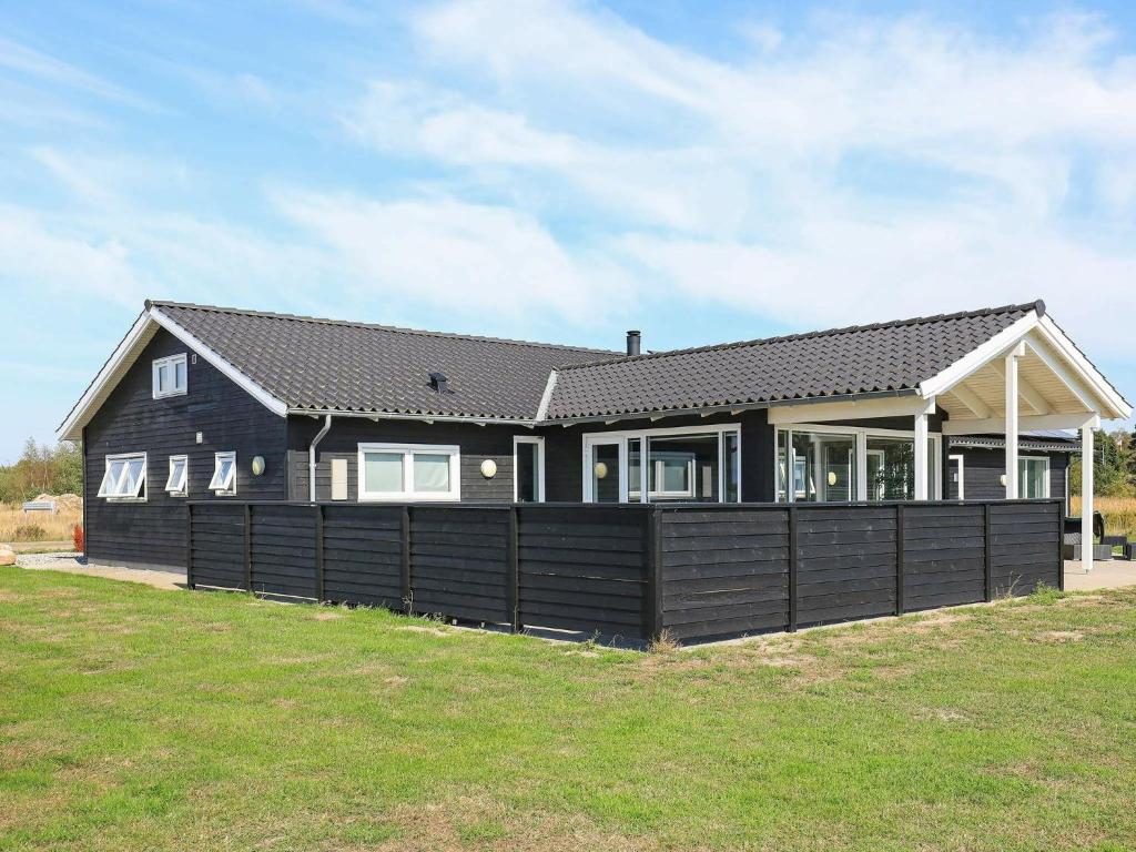 una casa con una valla negra delante de ella en 14 person holiday home in V ggerl se en Bøtø By
