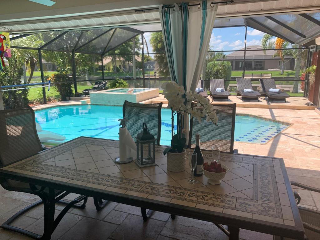 a table with bottles and flowers on it next to a pool at Villa Endless Love in Cape Coral