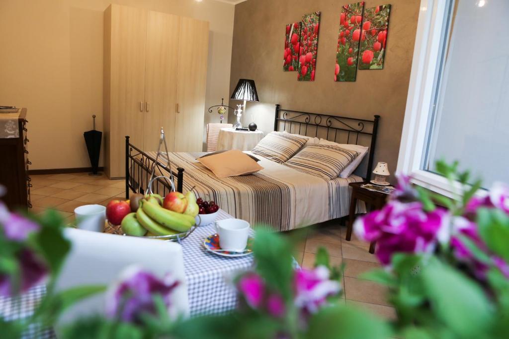 una camera da letto con un letto e un cesto di frutta su un tavolo di La casa di Ada a Sondrio