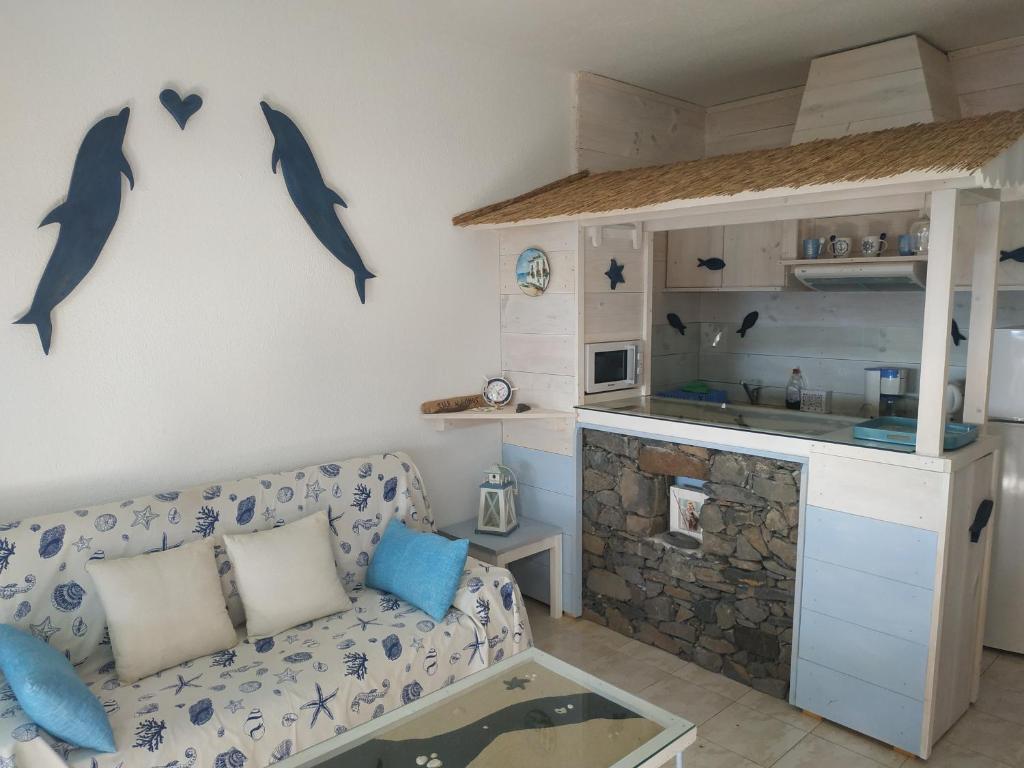sala de estar con sofá y delfines en la pared en Paradis, en Morro del Jable