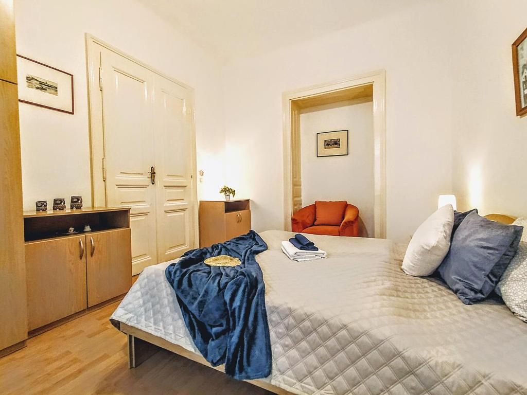 um pequeno quarto com uma cama e uma cadeira laranja em Apartments Historical Centre em Bratislava