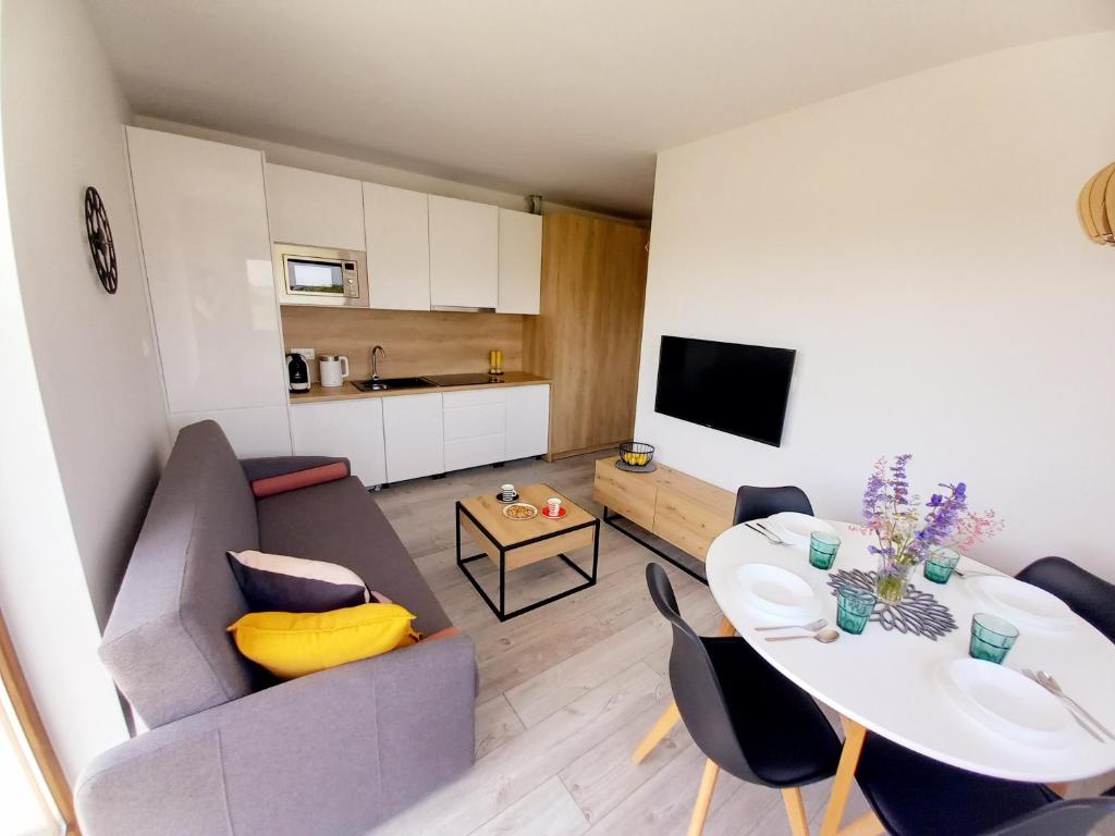a living room with a couch and a table at Apartament PLUS 22 C in Sarbinowo