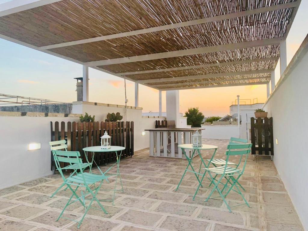 a patio with tables and chairs and a wooden ceiling at B&B Pietramare in Melendugno