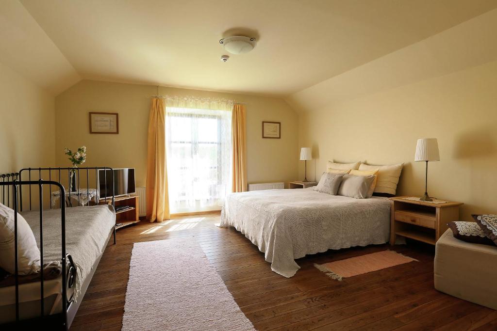 a bedroom with a bed and a window at Karlamuiza Country Hotel in Kārļi