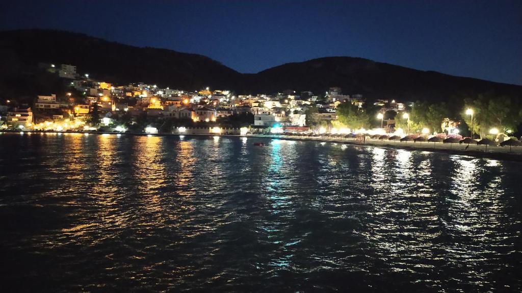 a view of a city at night from the water at Vrachos Κanari in Kivérion
