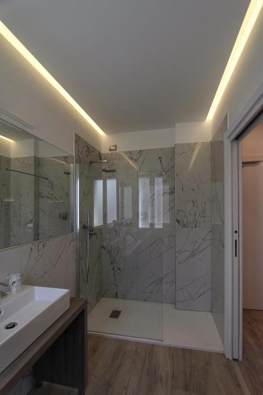 a bathroom with a shower and a sink and a tub at Hotel Belvedere in Venice-Lido