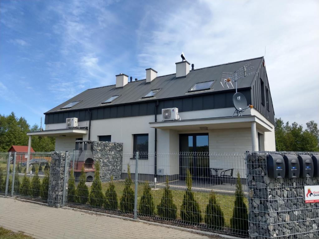 a white house with a black roof at Villa Anna in Międzywodzie