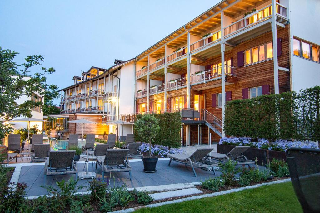 a building with chairs and tables in front of it at Hotel St. Florian in Frauenau