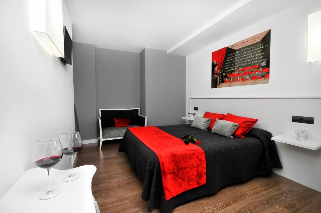 1 dormitorio con 1 cama con manta roja en CLÁ Hotel - Boutique en Teruel